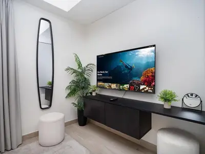 a living room with a flat screen tv on a dresser at Bright and Sleek Azizi Studio Prime Meydan Location in Dubai