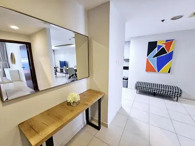 a living room with a table and a mirror at SUNRISE HOMES - Spacious 1BR next to Marina Walk in Dubai