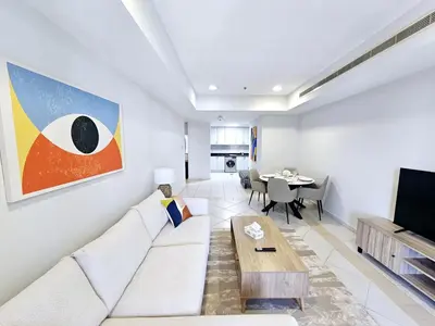 a living room with a white couch and a table at SUNRISE HOMES - Spacious 1BR next to Marina Walk in Dubai