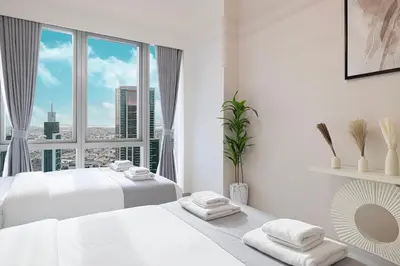 a white bedroom with two beds and a large window at Great View from 63th Floor! Amazing Pool with Burj View! Grande Signature! in Dubai