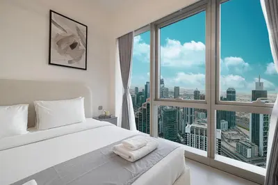 a bedroom with a white bed and a large window at Great View from 63th Floor! Amazing Pool with Burj View! Grande Signature! in Dubai