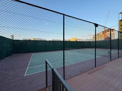 a tennis court with two tennis courts at Bright Studio Crystal Residence JVC in Dubai