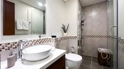 a bathroom with a sink and a toilet and a shower at KeyRock Living - Chic Reva 1BR with Pool Access in Dubai