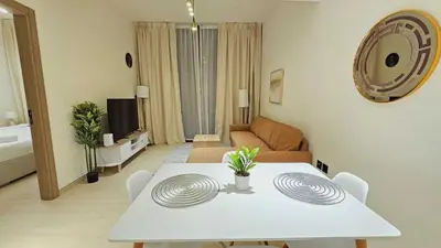 a living room with a white table and a couch at Spacious 1BR Apartment in Binghatti Emerald JVC in Dubai
