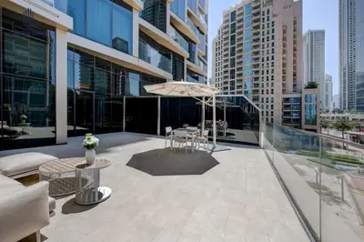 a patio with chairs and an umbrella on a building at Luxury 1-BR at Dubai Opera Stay in Dubai