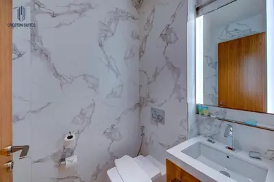 a white bathroom with a sink and a mirror at Luxury 1-BR at Dubai Opera Stay in Dubai