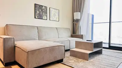 a living room with a couch and a table at Premium 1 Bed Apartment In Binghatti Venus in Dubai