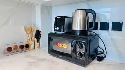 a microwave with a coffee pot on top of it at OYO HOME 1457 Premium 1bed Apartment In Jvc Bh in Dubai