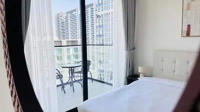 a bedroom with a bed and a balcony with a table at OYO HOME 1457 Premium 1bed Apartment In Jvc Bh in Dubai