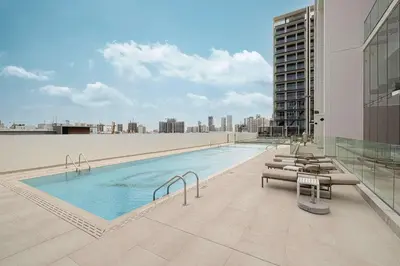 a swimming pool on the roof of a building at Cozy 1 BR with gym & pool just 15min to Dubai Marina in Dubai