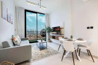 a living room with a table and a couch at Cozy 1 BR with gym & pool just 15min to Dubai Marina in Dubai