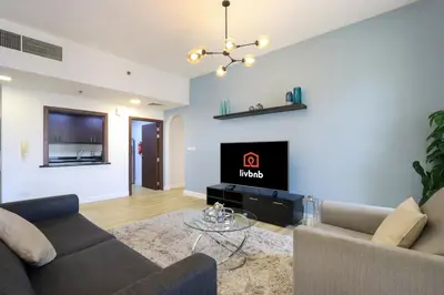 a living room with two couches and a tv at Livbnb - Scenic 2BHK with Amazing Marina Views in Dubai