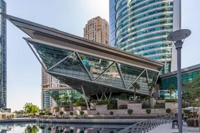 a glass building with a staircase in a city at Frank Porter - Lake Terrace Tower in Dubai