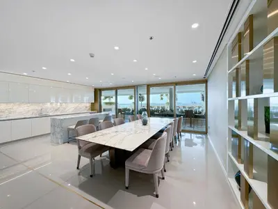 a dining room with a long table and chairs at Coastal Elegance 1-Bedroom in Grand Bleu in Dubai