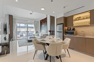 a kitchen and living room with a table and chairs at Coastal Elegance 1-Bedroom in Grand Bleu in Dubai