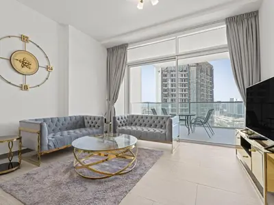 a living room with a couch and a glass table at Spacious and Cozy 1BDR in Hameni in Dubai