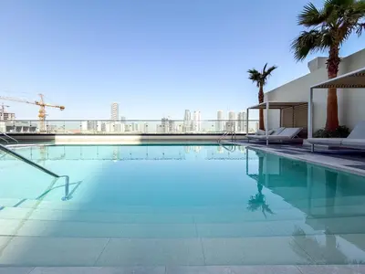 a swimming pool with a view of the city at Modern Chic Studio Apartment, Belgravia Heights 2, JVC Dubai in Dubai