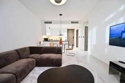 a living room with a couch and a dining room at Stunning 1 Bdr Luxury District one in Dubai