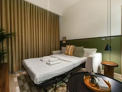 a room with a bed and a table and a couch at Stylish Azizi 1 Bedroom in Dubai