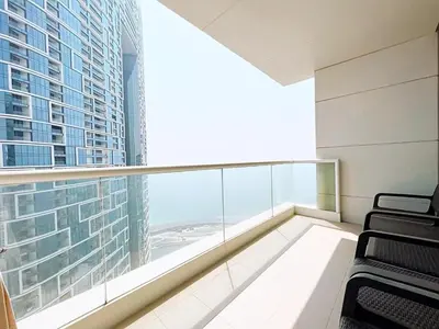 a balcony with chairs and a large window in a building at Private Beach Access - Canal View in Dubai