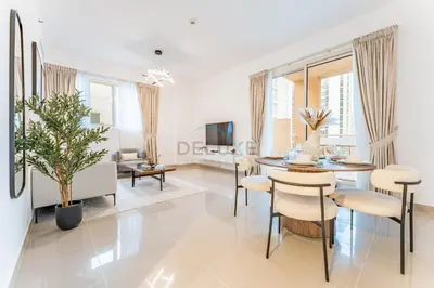 a living room with a table and chairs and a couch at City View 2BR Just Steps from the Mall, Roxana Residence B, Jumeirah Village Circle by Deluxe Holiday Homes in Dubai