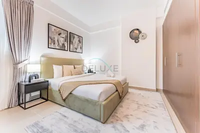 a white bedroom with a bed and a night stand at City View 2BR Just Steps from the Mall, Roxana Residence B, Jumeirah Village Circle by Deluxe Holiday Homes in Dubai