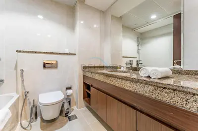a bathroom with a sink and a toilet and a mirror at City View 2BR Just Steps from the Mall, Roxana Residence B, Jumeirah Village Circle by Deluxe Holiday Homes in Dubai