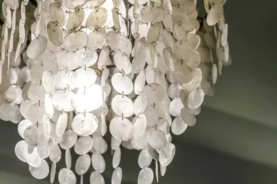 a chandelier with white shells hanging from the ceiling at 2BR in Downtown with Burj Khalifa & Fountain views in Dubai