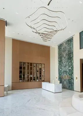 a lobby with a large chandelier hanging from the ceiling at Stylish 1br In Jvc Balcony, Pool & Free Parking in Dubai