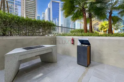 a trash can sitting next to a concrete bench at Dubai Canal and City Views 1BR, Minutes Drive to Burj Khalifa, DAMAC Zada Tower, Business Bay by Deluxe Holiday Homes in Dubai