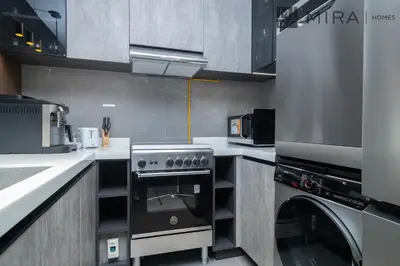 a kitchen with a stove and a dishwasher at Mira Holiday Homes - Newly and modern 1 bedroom with lake view in JLT in Dubai