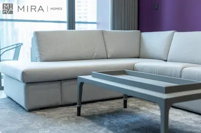 a couch and a coffee table in a room at Mira Holiday Homes - Newly and modern 1 bedroom with lake view in JLT in Dubai