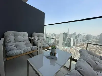 a living room with two couches and a table with a view at Bright 1br Jvc Balcony & Free Parking in Dubai