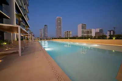 a swimming pool with a city skyline in the background at Bright 1br Jvc Balcony & Free Parking in Dubai