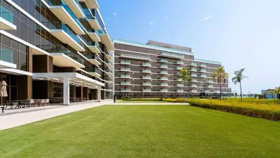 a large building with a lawn in front of it at AURA -Direct Seafront 2BR-Palm in Dubai
