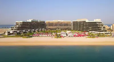 a hotel on the beach with the ocean in front of it at AURA -Direct Seafront 2BR-Palm in Dubai