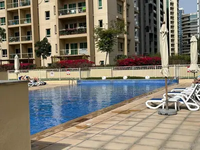a swimming pool with chairs and umbrellas in a building at Serene Getaway in Dubai
