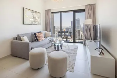 a living room with a couch and a tv and a table at Frank Porter - Burj Royale in Dubai