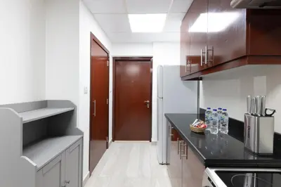 a kitchen with black counter tops and a brown door at Luxe 2BR Dubai Retreat with Ain Dubai View for 6 guests in Dubai