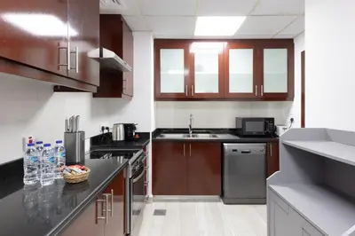 a kitchen with wooden cabinets and stainless steel appliances at Luxe 2BR Dubai Retreat with Ain Dubai View for 6 guests in Dubai