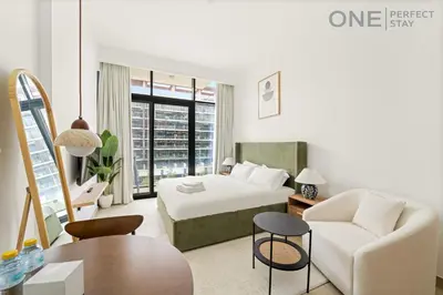 a hotel room with a bed and a couch at Cozy Studio Apartment in Meydan in Dubai