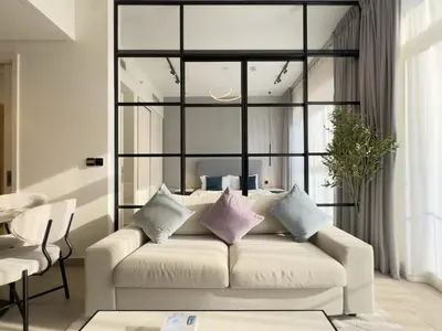 a living room with a white couch with purple pillows at Cozy 1BR in Socio Dubai Hills Near Mall and Park in Dubai