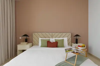 a bedroom with a large white bed with green and red pillows at Elite Escape - 3 BHK Burj View & Dubai Mall Access in Dubai