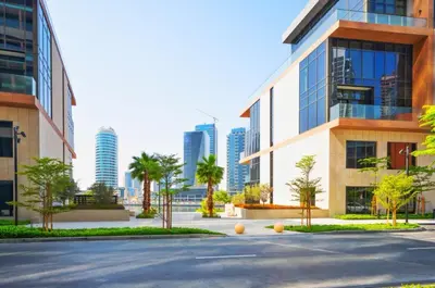 a parking lot in front of a building with palm trees at High Floor Burj and Canal View Business Bay in Dubai