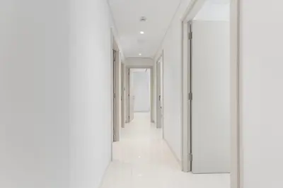 an empty hallway with white walls and white floors at Full Sea View & Dubai Skyline - 4BR LUX Beachfront in Dubai