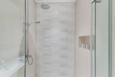 a shower with a glass door in a bathroom at Full Sea View & Dubai Skyline - 4BR LUX Beachfront in Dubai