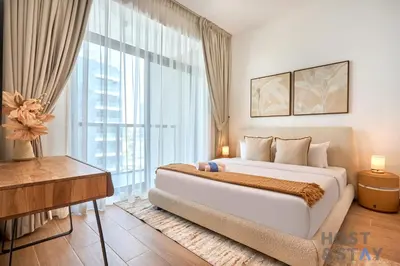 a bedroom with a large bed and a large window at Boho-Chic Comfort - 1BR Haven - Marquis 2020 Arjan in Dubai