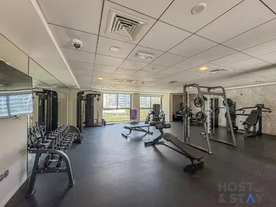 a gym with several treadmills and tread machines at Boho-Chic Comfort - 1BR Haven - Marquis 2020 Arjan in Dubai