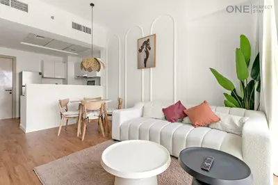a living room with a couch and a table at 1BR with Balcony Near Metro Station in Dubai