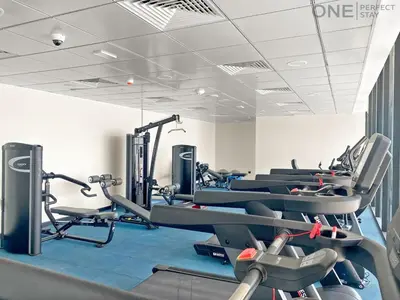a row of tread machines in a gym at 1BR with Balcony Near Metro Station in Dubai